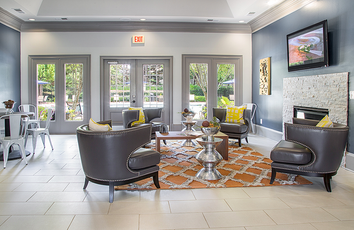 Chic and modern lounge area with elegant dark leather chairs, stylish decor, and large windows offering a bright and inviting ambiance.