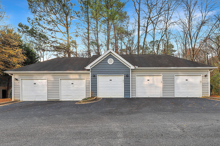 Charming apartment community showcasing modern garages with sleek design and surrounded by serene natural landscape.