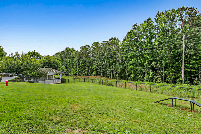 Expansive green yard with lush trees and a charming pavilion, perfect for outdoor relaxation.