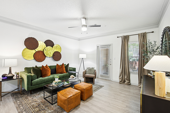 Inviting living room with a modern green sofa, stylish wall art, and sleek hardwood floors, offering a cozy and elegant atmosphere.