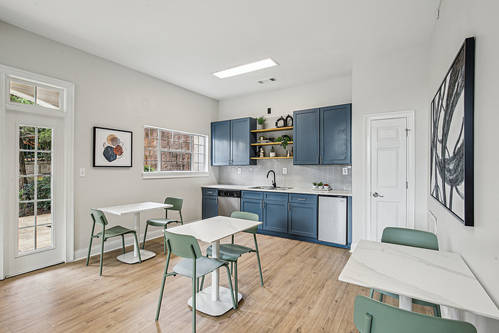 Bright and modern dining area with vibrant teal cabinets, sleek countertops, and stylish decor.