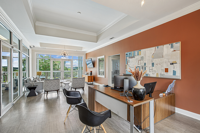 Elegant leasing office featuring modern decor, large windows with scenic views, and a stylish office setup.