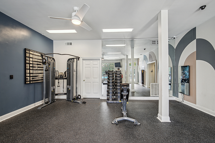 Modern apartment fitness center with sleek exercise equipment, mirrored walls, and stylish geometric accents.