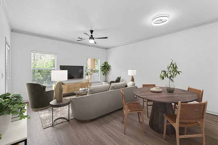 Bright and inviting living room with modern furniture, a round dining table, and large windows allowing natural light to fill the space.