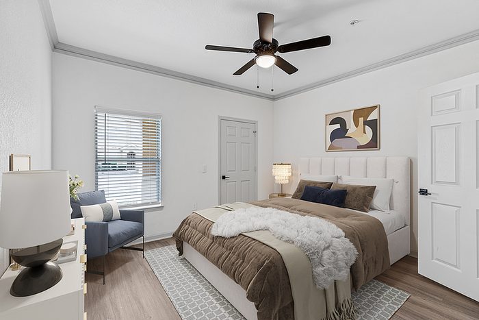 Bright and cozy bedroom featuring a plush bed, elegant decor, and natural light streaming through a window with blinds.