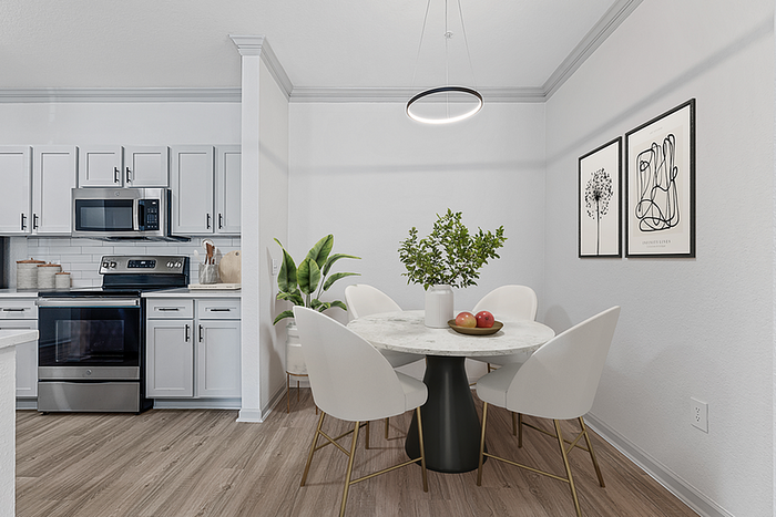 Modern kitchen and dining area with sleek white cabinets, stainless steel appliances, and elegant decor, perfect for stylish living.