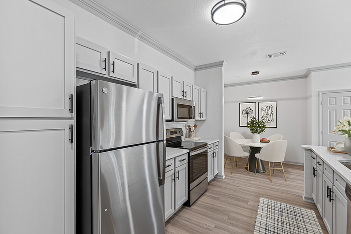 Bright modern kitchen with sleek stainless steel appliances, elegant cabinetry, and a cozy dining area adorned with stylish decor.