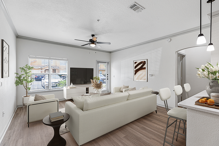 Bright and inviting living room with modern furniture, natural light, and stylish decor, connected to a sleek kitchen with bar seating.