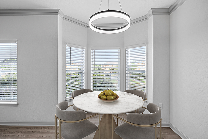Bright dining area with sleek marble round table, elegant chandelier, and large windows providing scenic views.