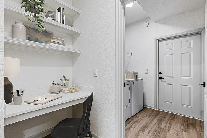 Chic home office nook with built-in shelves and cozy laundry area, featuring stylish decor and a modern aesthetic.