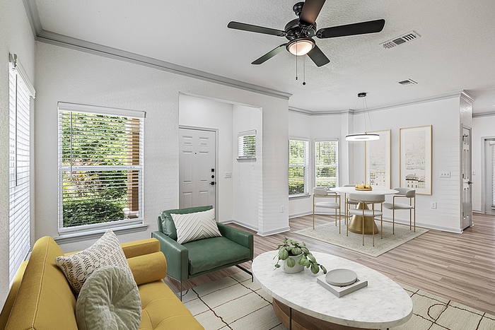 Bright and inviting living space featuring a modern open layout, stylish seating, and a chic dining area with natural light streaming through large windows.