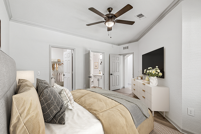 Inviting bedroom featuring luxury bedding, modern decor, and a spacious walk-in closet with ample storage.