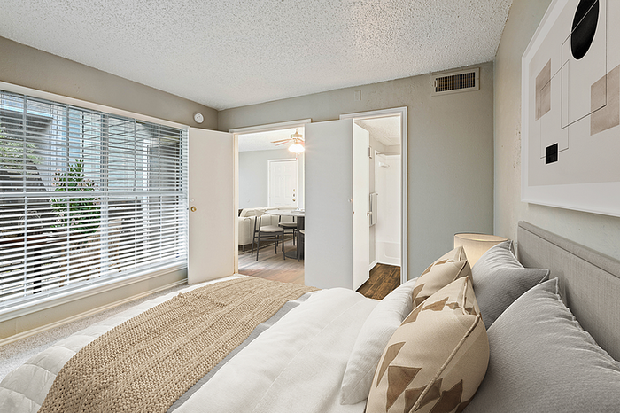 Bright and inviting bedroom with large windows, cozy bed, and elegant decor, seamlessly connected to a stylish dining area.