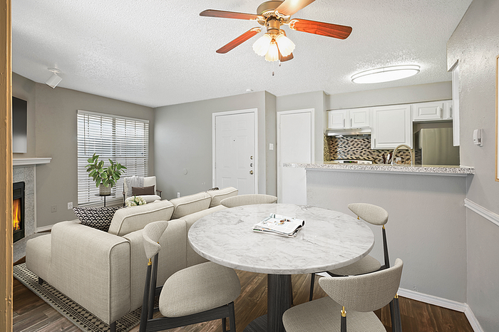 Modern open-concept living space with cozy fireplace, elegant dining area, and sleek kitchen, featuring chic decor and inviting atmosphere.