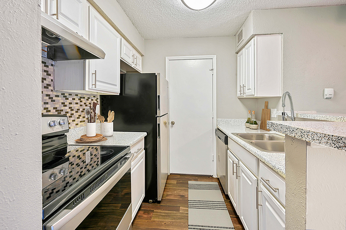 Chic modern kitchen featuring sleek countertops, stainless steel appliances, and stylish tile backsplash.