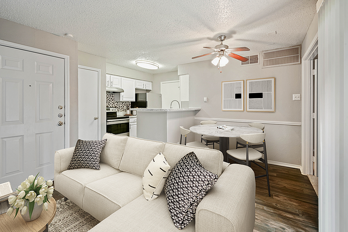 Charming open-concept living space featuring a cozy sofa, modern dining area, and sleek kitchen with contemporary design touches.