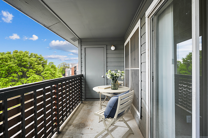 Charming balcony with seating and scenic views, perfect for relaxation in a modern apartment setting.