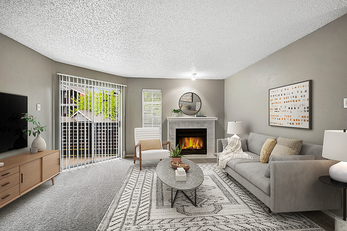 Inviting living room with modern decor, cozy fireplace, and elegant sliding glass doors leading to a balcony.