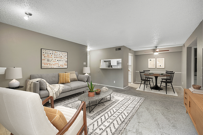 Modern open-concept living and dining area with stylish furniture, soft lighting, and contemporary artwork.