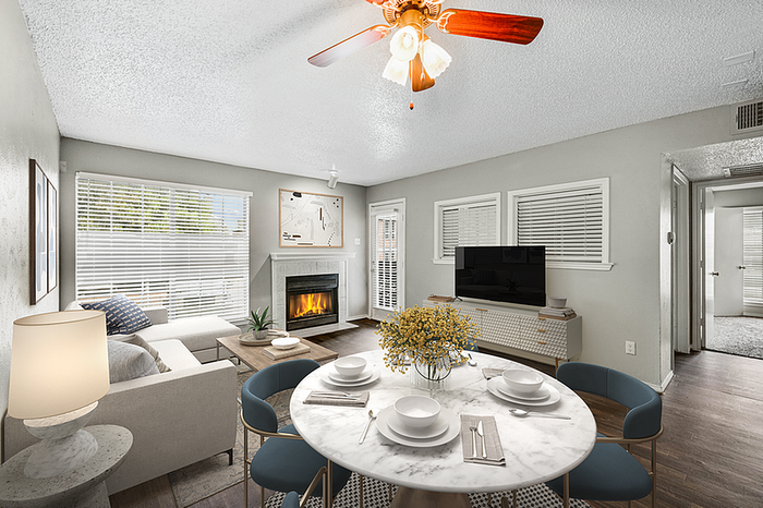 Inviting living room with a cozy fireplace, elegant dining area, modern decor, and ample natural light through large windows.
