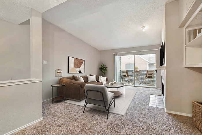 Bright and inviting living room featuring cozy sectional sofa, stylish decor, and a private balcony with seating.