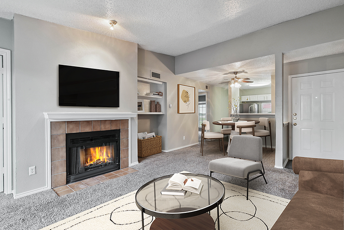 Inviting living room with cozy fireplace, modern furnishings, and open-concept dining area leading to a bright kitchen.