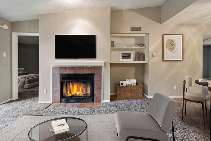 Inviting living room with a cozy fireplace, modern furniture, and elegant decor, leading to a serene bedroom.