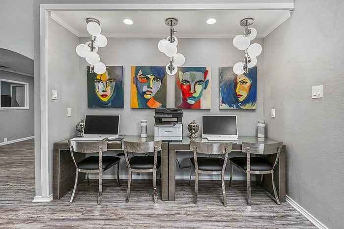 Modern Business Center with sleek metallic desks, contemporary art paintings, and chic lighting fixtures, perfect for productivity and creativity.