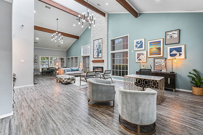 Contemporary open-concept clubhouse with high ceilings, modern decor, and abundant natural light, creating a warm and inviting atmosphere.