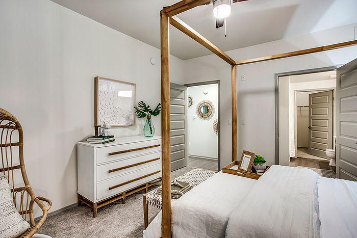 Charming bedroom with a cozy ambiance, featuring a modern dresser, stylish decor, and ample natural light.