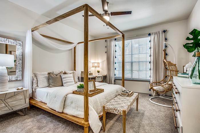 Chic bedroom with a cozy canopy bed, stylish decor, and a sunlit window for a perfect retreat.