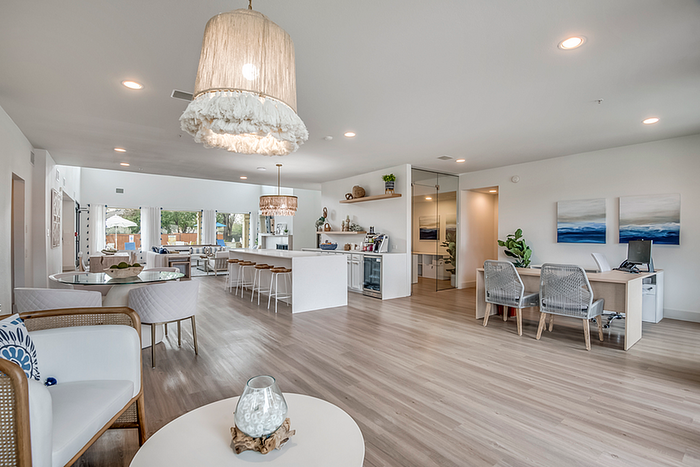 Modern open-concept living space featuring elegant lighting, stylish seating, and a spacious kitchen with a breakfast bar.