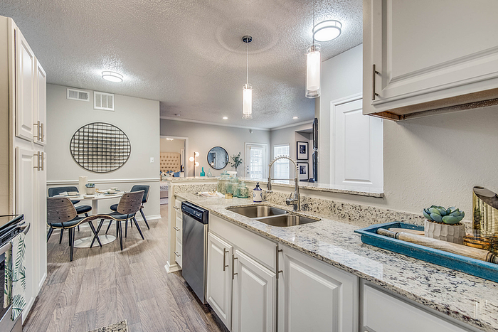 Chic open-concept kitchen and dining area showcasing modern countertops, sleek lighting, and contemporary decor.