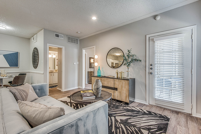 Modern living room with stylish decor, featuring a cozy sofa, chic wooden furniture, and elegant lighting under soft ambient lighting.