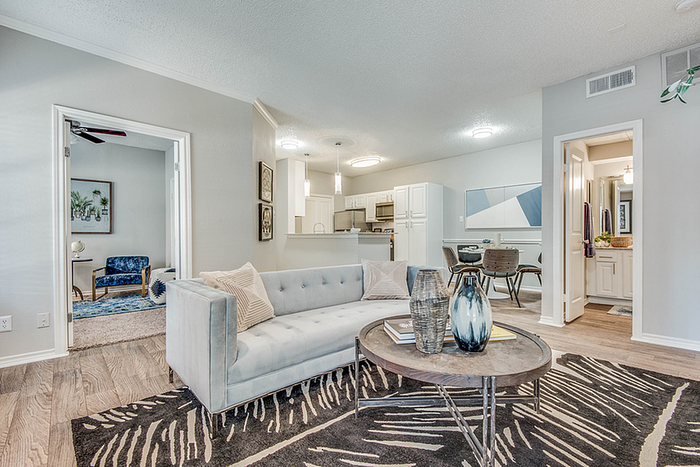 Inviting open-plan living space with chic decor, featuring a plush sofa, modern dining area, and contemporary kitchen design.