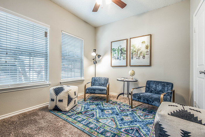 Bright and inviting living space with plush seating, vibrant patterned rug, and chic wall art creating a cozy ambiance.