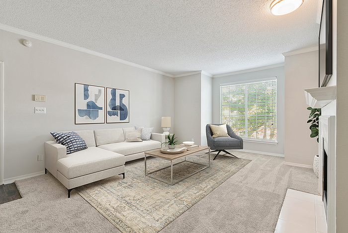 Bright, contemporary living room featuring a cozy sectional sofa, chic decor, large window with natural light, and a modern armchair for stylish comfort.