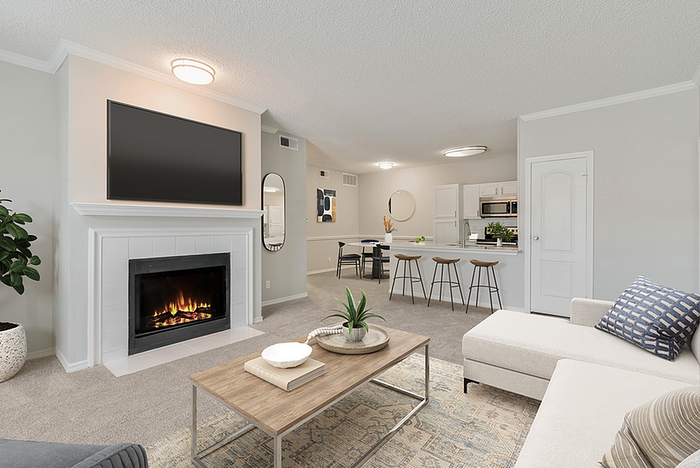 Elegant living space featuring a cozy fireplace, modern open-concept kitchen, and chic decor, offering a warm and inviting atmosphere.