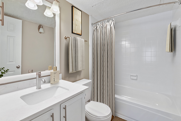 Elegant bathroom with modern fixtures, a sleek marble countertop, and chic lighting, perfect for a serene retreat.
