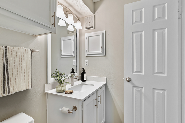 Bright and elegant bathroom featuring modern vanity, sleek fixtures, and ample storage.