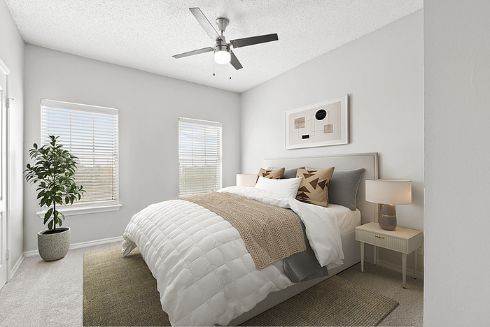 Bright and inviting bedroom with modern decor, featuring a cozy bed, stylish artwork, and natural light through large windows.