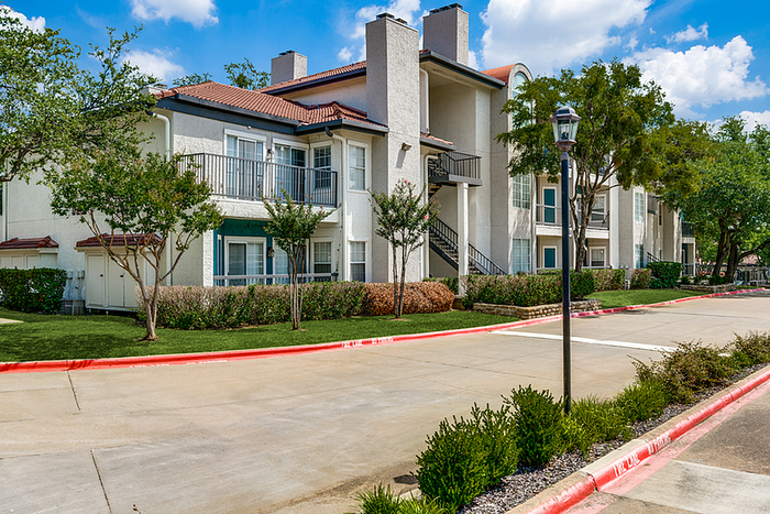 Charming apartment community with modern architecture, lush greenery, and a peaceful suburban setting.