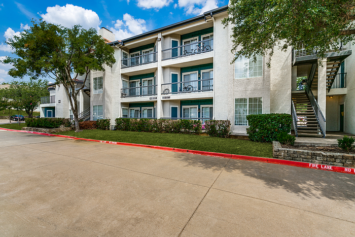 Charming three-story apartment building with lush greenery and modern balconies, perfect for comfortable living.