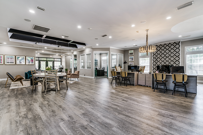 Spacious and modern clubhouse featuring elegant hardwood floors, contemporary seating, and stylish chandeliers, perfect for relaxation and socializing.