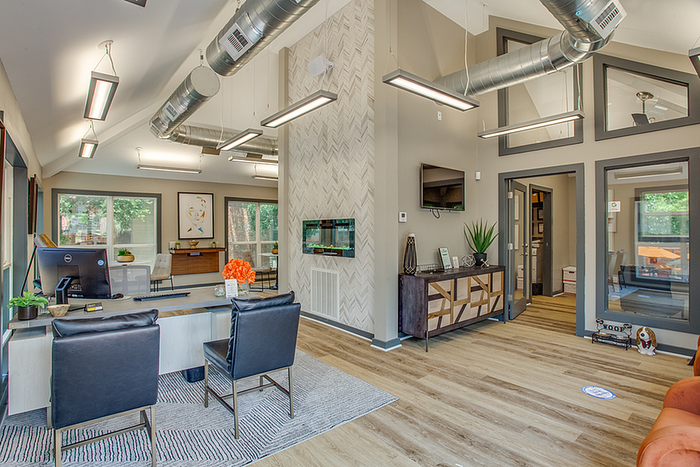 Modern office space featuring sleek design with stylish furniture, natural light from large windows, and contemporary decor.