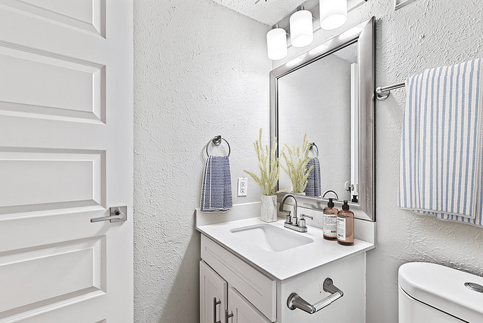 Bright and modern bathroom featuring sleek white design, elegant vanity, and ambient lighting with stylish accents.