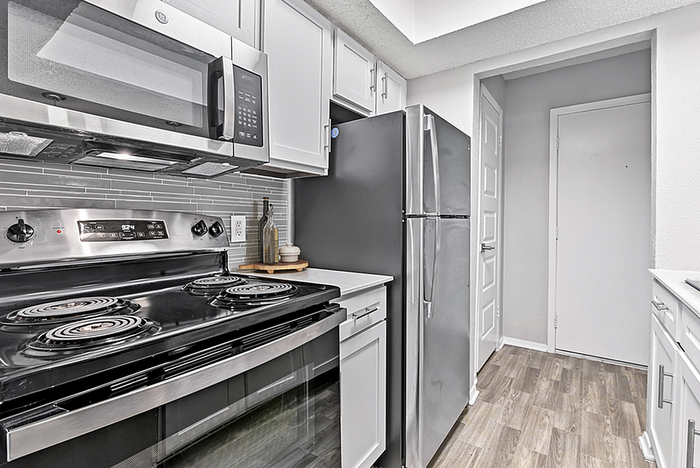 Contemporary kitchen with sleek stainless steel appliances, modern cabinetry, and chic tile backsplash.