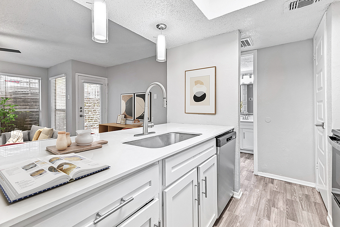 Modern kitchen with sleek white cabinetry, stainless steel appliances, and stylish open-concept living space.