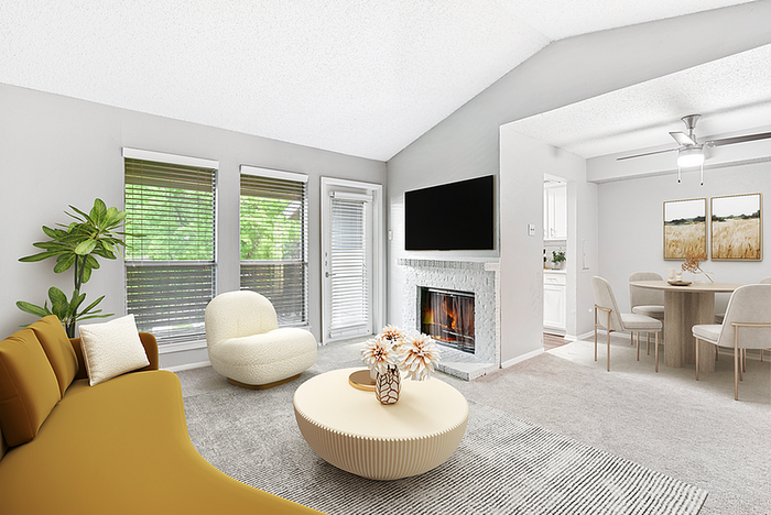 Elegant living room with modern furniture, abundant natural light, and cozy fireplace leading to a stylish dining area and kitchen.