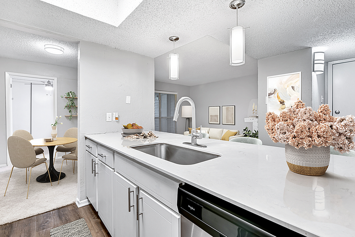 Modern, stylish open-plan kitchen and dining area in a cozy apartment, featuring sleek countertops, elegant pendant lighting, and a welcoming dining nook.